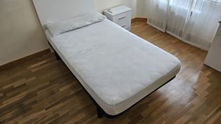 Dos camas individuales con cabecero y mesita