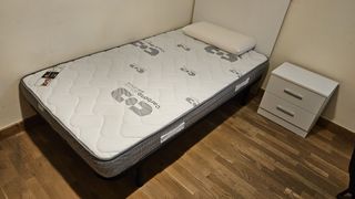 Dos camas individuales con cabecero y mesita