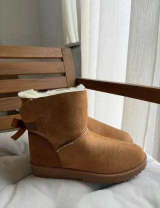 Botas marrones tipo UGG con pelo y lazo