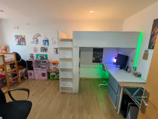 Cama alta con escritorio y estanterías Ikea.