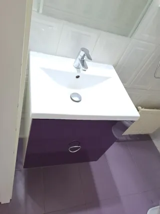 Mueble de baño morado con lavabo y espejo