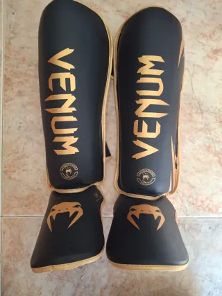 Espinilleras Venum Negras y Doradas