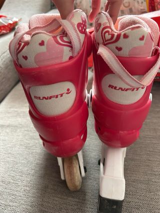 Patines rosa y blanco de tres ruedas, lineal.