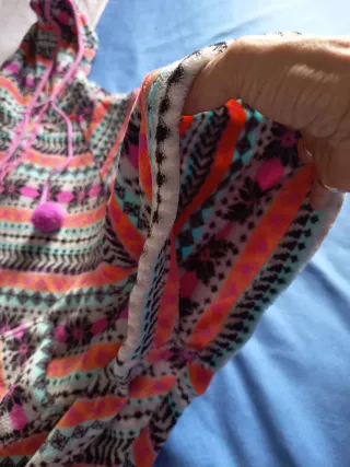 Poncho multicolor con capucha y pompones