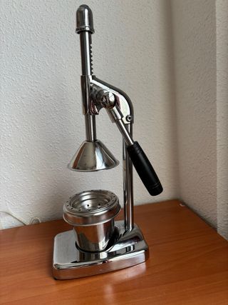 Exprimidor manual de metal plateado