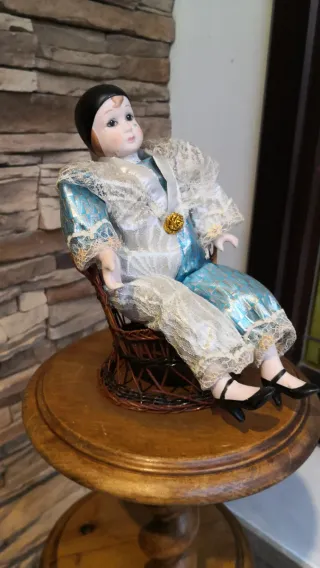 Muñeco de porcelana con silla de mimbre