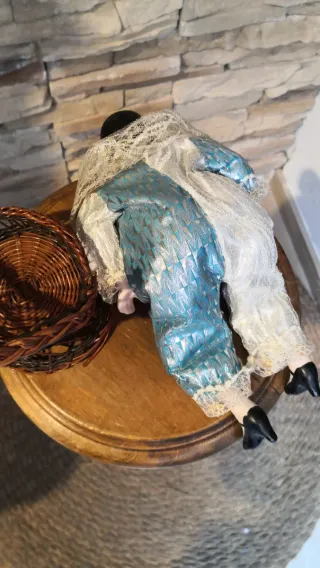 Muñeco de porcelana con silla de mimbre