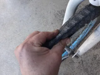 Bicicleta BMX blanca y azul cubiertas en mal estad