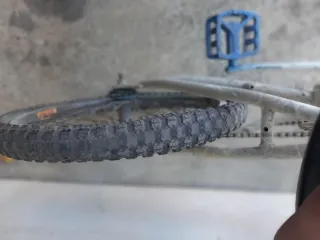 Bicicleta BMX blanca y azul cubiertas en mal estad