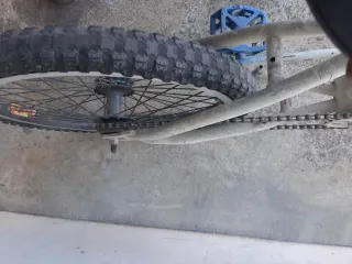 Bicicleta BMX blanca y azul cubiertas en mal estad