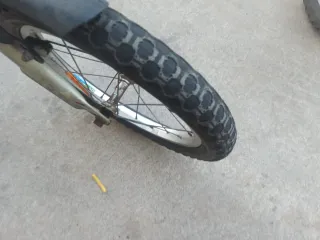 Bicicleta BMX blanca y azul cubiertas en mal estad