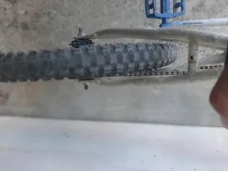 Bicicleta BMX blanca y azul cubiertas en mal estad