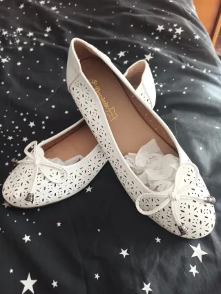 Zapatos planos blancos con lazo