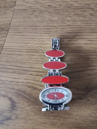 Reloj de pulsera ovalado con detalles rojos