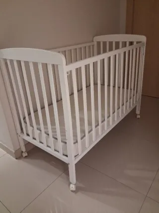 Cuna de bebé blanca con ruedas Incluye colchón.