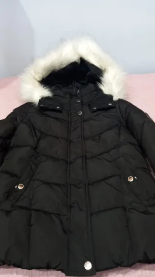 Chaqueta negra acolchada con capucha con pelo.