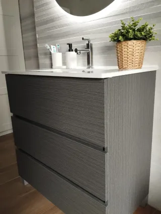 Mueble de baño gris con lavabo y grifo