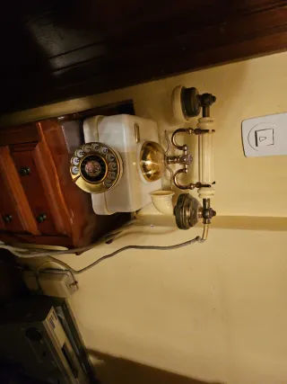 Teléfono antiguo dorado y blanco