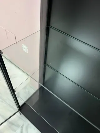 Vitrina expositora negra con puertas de cristal