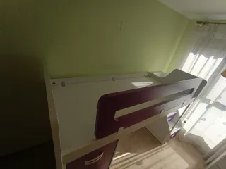 Cama litera con armario, escaleras y mesita.