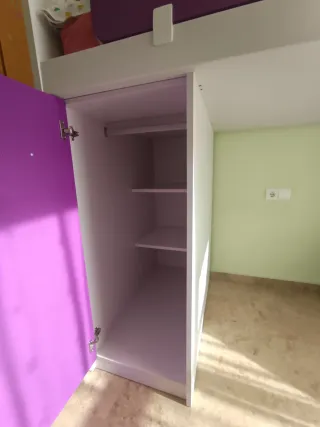 Cama litera con armario, escaleras y mesita.