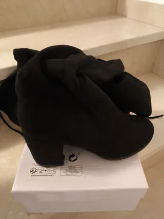 Botas altas negras por encima de la rodilla