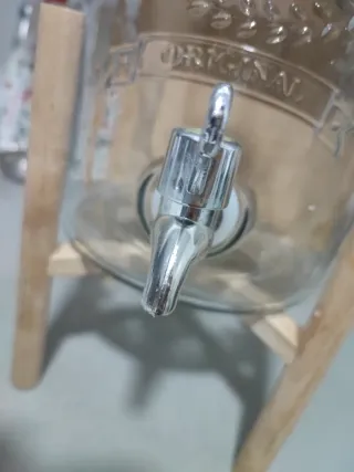 Dispensador de vidrio con soporte de madera.