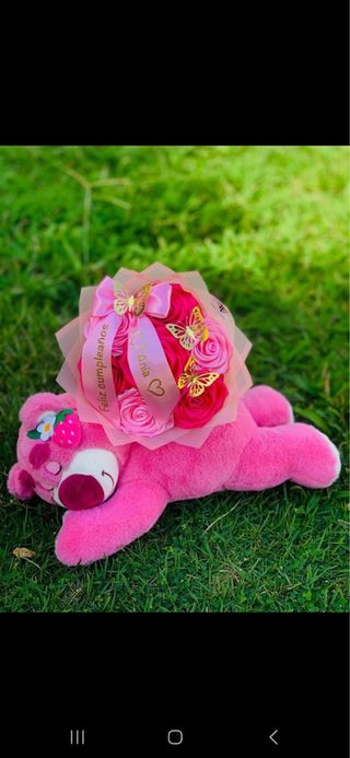 Oso de peluche rosa con ramo de flores