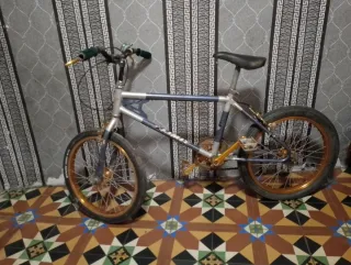 Bicicleta BMX plateada y dorada
