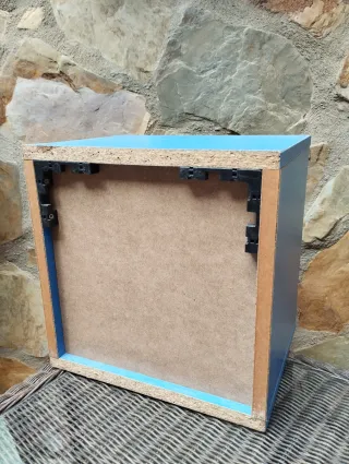 Estanterías verdes y cubo azul de madera