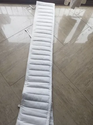 Protector de cuna acolchado blanco Ikea.