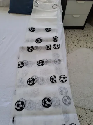 Cortina blanca con balones de fútbol bordados