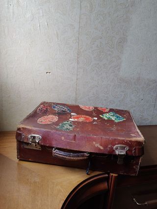 Maleta antigua con pegatinas de viaje + periódicos
