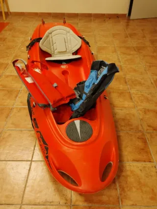 Kayak rojo con chalecos salvavidas