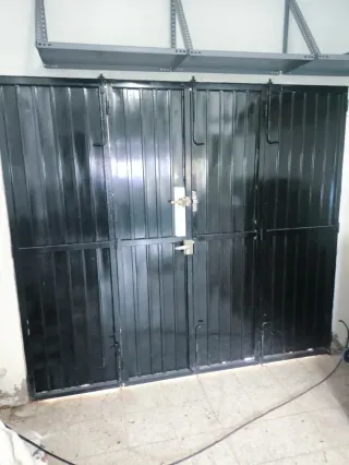 Puerta de garaje negra acordeón a dos lados