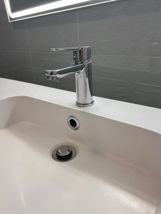 Mueble de baño con lavabo blanco y patas