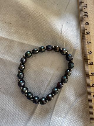 Pulseras de perlas negras y plateadas