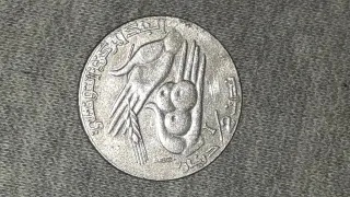 Moneda antigua con ave y mano