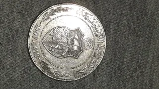 Moneda antigua con ave y mano