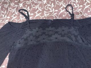 Blusa negra manga larga hombros descubiertos.