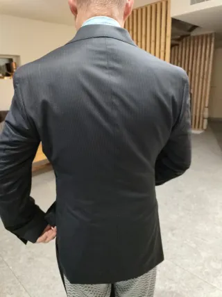 Traje negro dé ceremonia, es de verano.