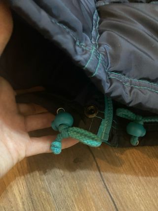 Chaqueta plumífera negra y turquesa