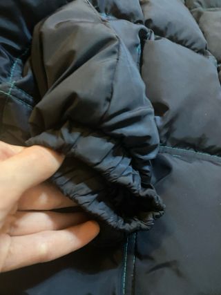 Chaqueta plumífera negra y turquesa