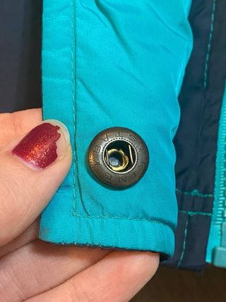 Chaqueta plumífera negra y turquesa