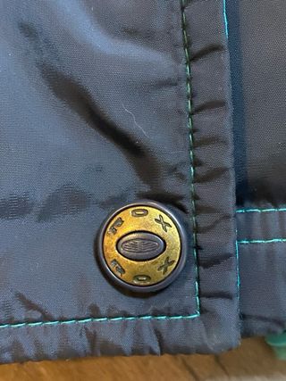 Chaqueta plumífera negra y turquesa