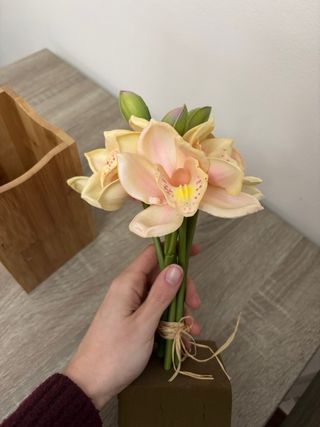 Flores artificiales y jarrón de madera