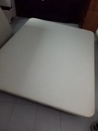 Cama grande de tela blanca y base tapizada