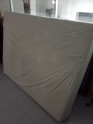 Cama grande de tela blanca y base tapizada