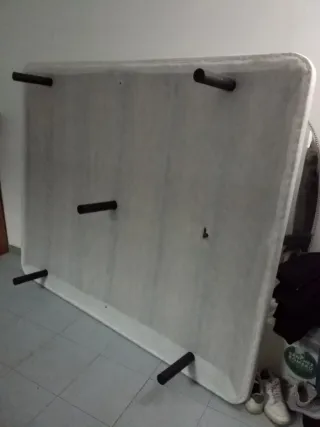 Cama grande de tela blanca y base tapizada