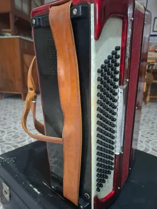 Acordeón rojo, teclas blancas y negras, caja tpte